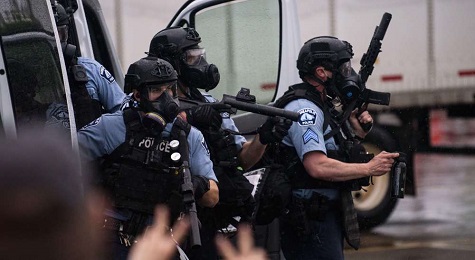 Police dressed in tactical gear attempt to disperse crowds gathered to protest the death of George Floyd on May 26, 2020, in Minneapolis, Minnesota.