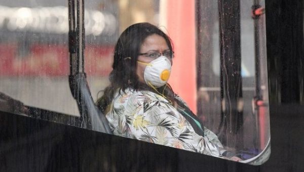 A woman wearing a face mask is seen on a bus in Santiago, Chile, April 7, 2020.