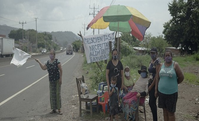 Families beg for food on the road to Sonsonate, in the municipality of Colon, El Salvador. July 2020