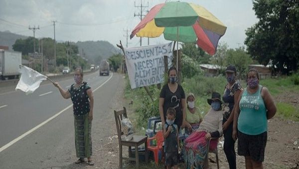 Families beg for food on the road to Sonsonate, in the municipality of Colon, El Salvador. July 2020
