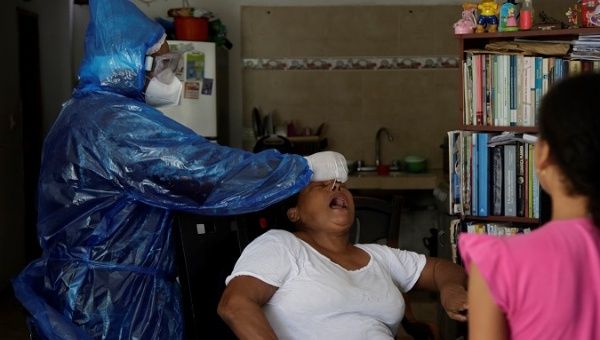 A health professional perform a Covid-19 PCR test to a woman in a neighbourhood in Cartagena, Colombia. July 13.