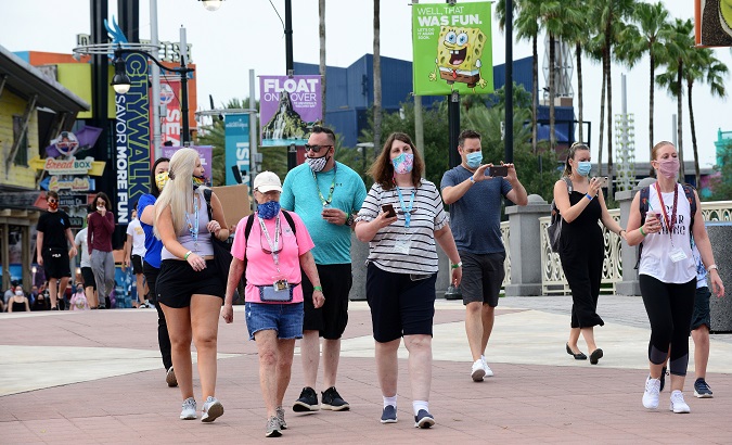 Citizens with face masks walk through Universal Studios' theme park in Orlando, Florida, U.S., June 13, 2020.