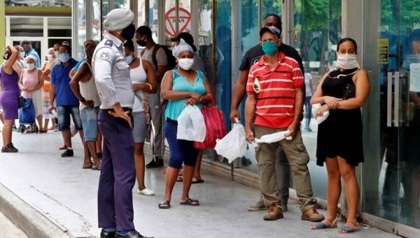 People with face masks line up outside a Mall in Havana, Cuba, June 21, 2020.