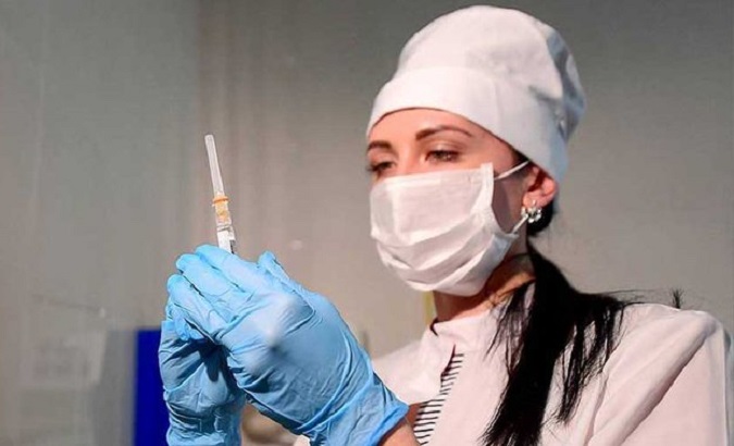 Health worker holding a syringe.