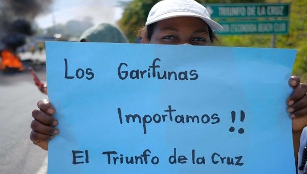 Garifuna woman holds up a sign that reads 'We Garifunas matter' in the community of Triunfo de la Cruz, Atlántico department, Honduras. July 22, 2020.