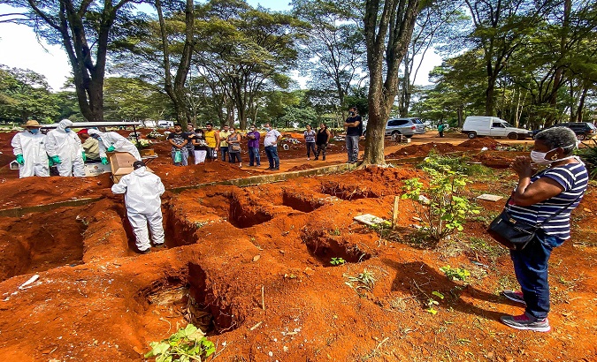 Funeral service employees bury a COVID-19 victim at the Vila Formosa cemetery in São Paulo, Brazil. July, 2020.