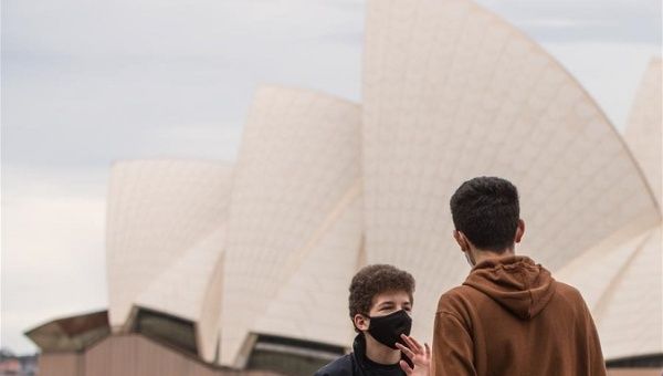 People talk near the Sydney Opera House in Sydney, Australia, on Aug. 12, 2020.