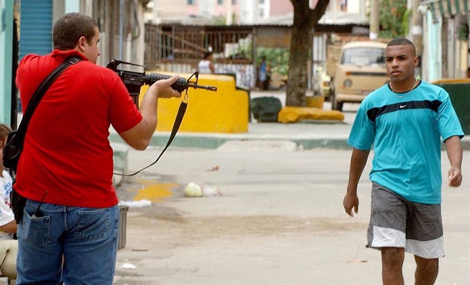 A policeman points to a citizen walking in a poor neighborhood (favela), Rio de Janeiro. Brazil.