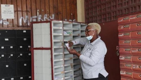 A postal worker delivers letters to mailboxes at the Carenage office in Trinidad and Tobago, May 8, 2020.