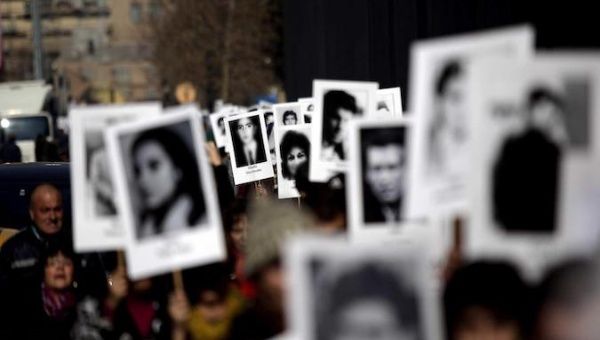 People hold pictures of missing persons during a protest in Buenos Aires, Argentina.