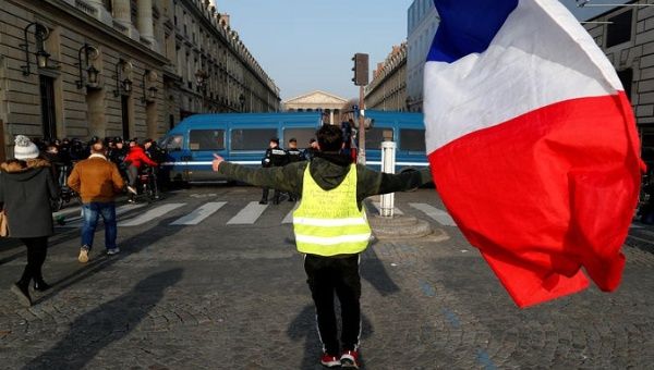 A demonstrator wearing a yellow vest holds a French flag during a demonstration in Paris, France, January 24, 2020.