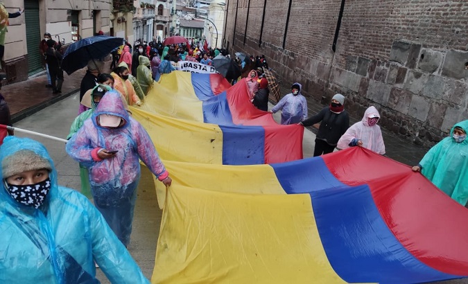 Citizens hold the national flag as they march through the streets, Quito, Ecuador, Sept. 16, 2020.