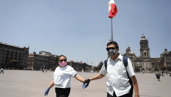 A couple walks trough the Zocalo square, Mexico City, Mexico, August 4, 2020.