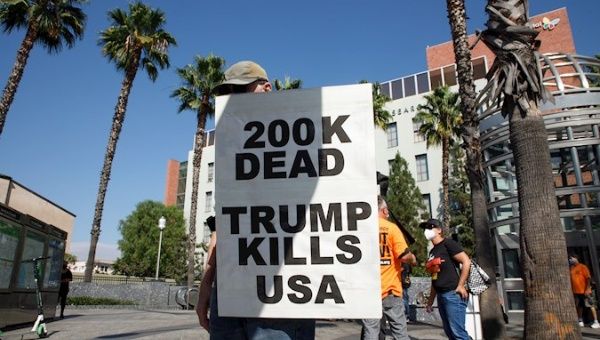 A protester holds a sign demonstrating against US President Donald Trump and the death of 200,000 people in the US from the COVID-19 pandemic. Los Angeles, California, USA. September 21, 2020. 