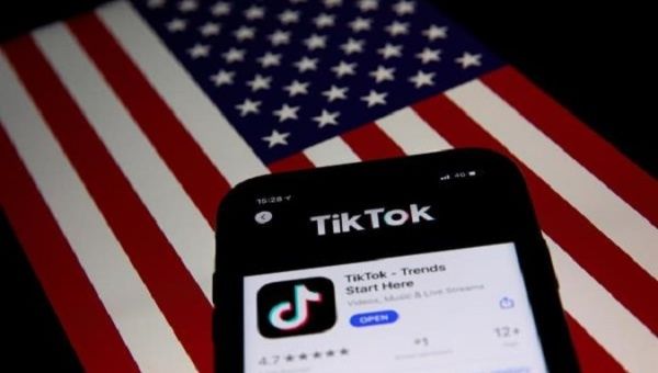 TikTok application in a phone placed in front of the U.S. flag, Sept. 24, 2020.
