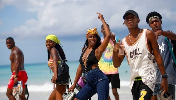 Young Cubans smile for the camera as they walk Havana's eastern beaches amidst the province's 