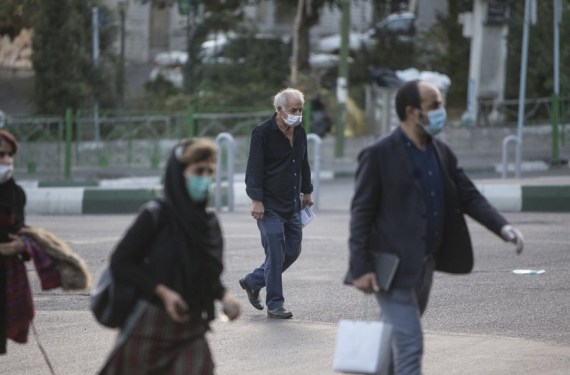 People wearing face masks cross a street in Tehran, Iran, Oct. 21, 2020.
