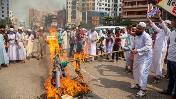 Members of the Islami Andolan Bangladesh party burn an image of French President Emmanuel Macron as they take part in a march towards the French Embassy in Dhaka, Bangladesh, October 27, 2020.