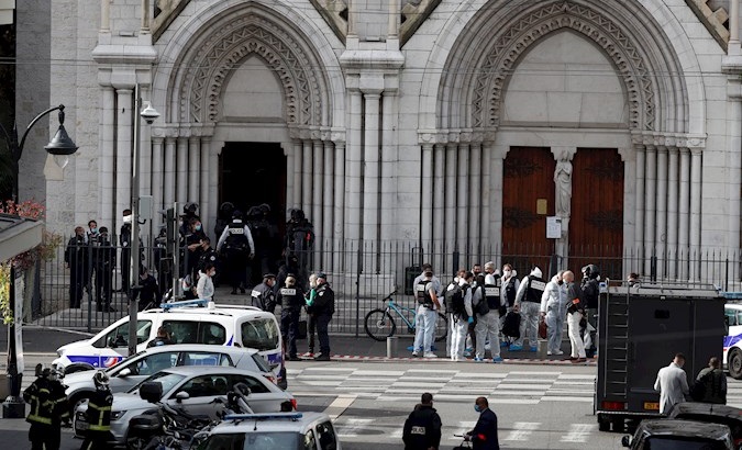 Police officers stand at the entrance of the Notre Dame church in Nice, France, Oct. 29, 2020.