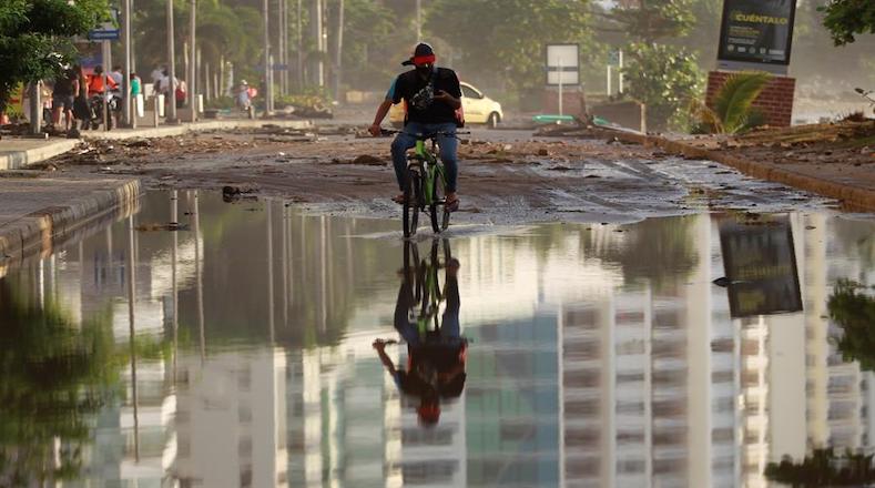 A cyclist crosses a flooded avenue after Hurricane Iota passes through Cartagena, Colombia, Nov. 16, 2020. 