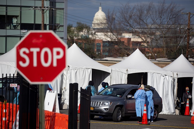 People in vehicles are tested with a swab at a drive-thru COVID-19 testing site operated by the District of Columbia, with the US Capitol seen in the background, in Washington, DC, USA, 18 November 2020.