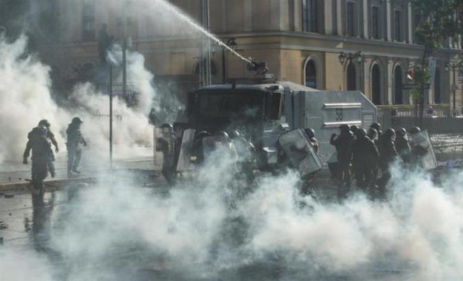 Carabineros repress a protest with pressurized water and tear gas bombs, Santiago, Chile, Nov. 20, 2020.