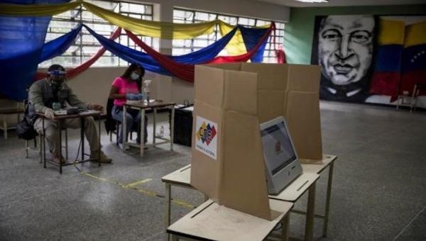 An image of Commander Hugo Chavez hangs in a polling station in Caracas, Venezuela, Dec. 6, 2020.