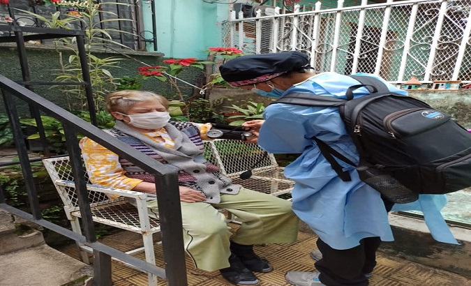 A doctor checks on an elderly woman in the Kennedy neighborhood, Buenos Aires, Argentina, Dec. 7, 2020.