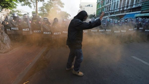 Police fence in front of a protester, Thailand, 2020.
