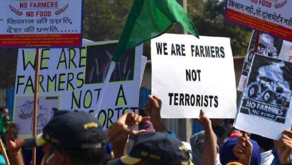 Farmers hold signs rejecting police brutality, India, 2020.