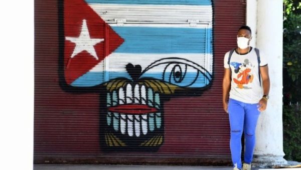 A man wearing a face mask walks on the street in Havana, Cuba, Aug. 10, 2020. 