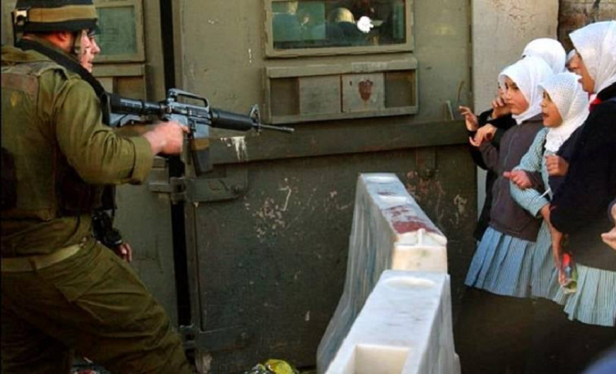 Palestinian students are threatened by Israeli occupation soldiers, Feb. 12, 2021.