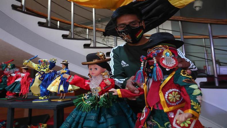 Artisan Hugo Ramos shows miniature figures of the 'chuta' and 'chola paceña' carnival characters, La Paz, Bolivia, Feb. 11, 2021.