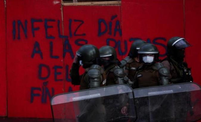 Police officers patrol protesters in Plaza Italia, Santiago, Chile, April 27, 2021.