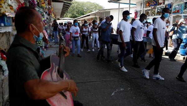 Several people carry the coffin with the body of Deiner Castillo, a 20 year old murdered on February 8, 2021, as they walk through the Bellavista neighborhood in a human chain calling for peace in  Colombia. 