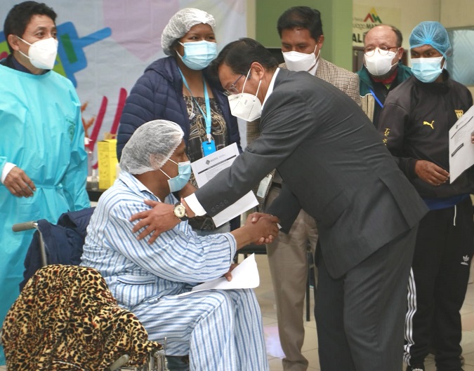Bolivia's President Luis Arce exchange with patients during the inauguration of the  COVID-19 vaccination campaing in La Paz on March 1, 2021.