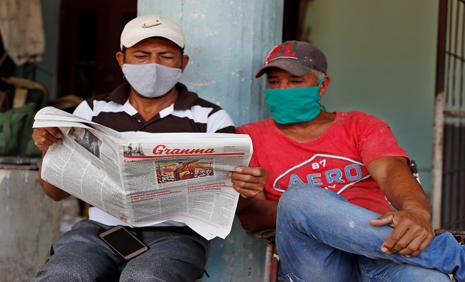 Two men read local outlet Granma, Havana, Cuba, Feb. 18, 2021.