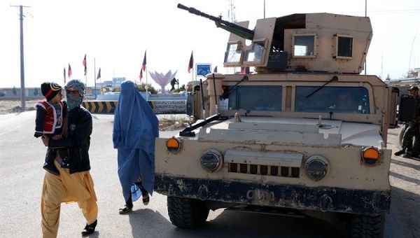 A family walking by a military vehicle in Herat, Afghanistan, Nov. 28, 2020.