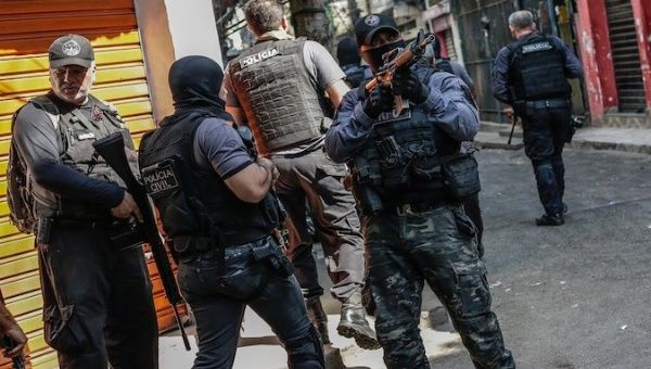  Police officers point guns at residents of the Jacarezinho community, Rio de Janeiro, Brazil, May 6, 2021.