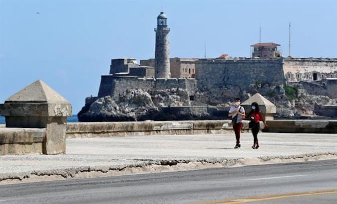 A couple walks along the Malecon, Havana, Cuba, April 24, 2021.