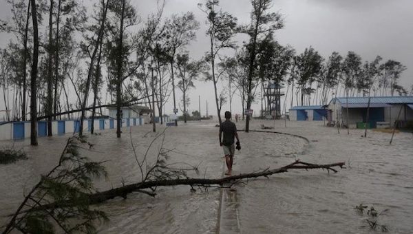 A man walks through a flooded area in West Bengal, India, May 26, 2021.