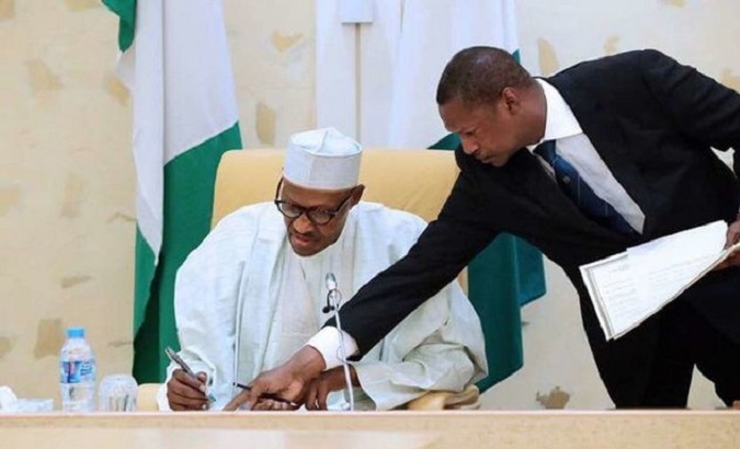President Muhammadu Buhari (L) signing documents, Nigeria.