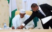 President Muhammadu Buhari (L) signing documents, Nigeria.