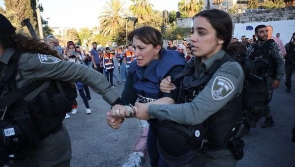 Israeli officers arresting journalist Givara Budeiri (C), Sheikh Jarrah, occupied East Jerusalem, June 5, 2021.