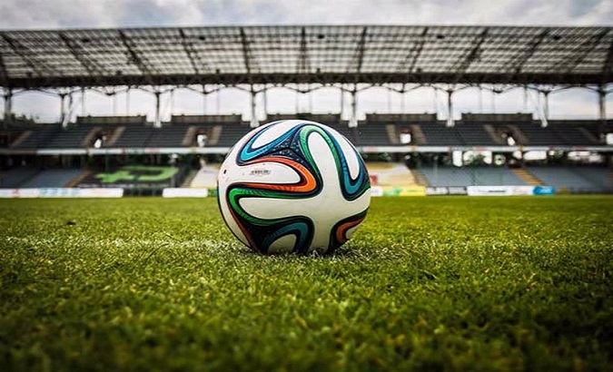A ball in the middle of a soccer field.