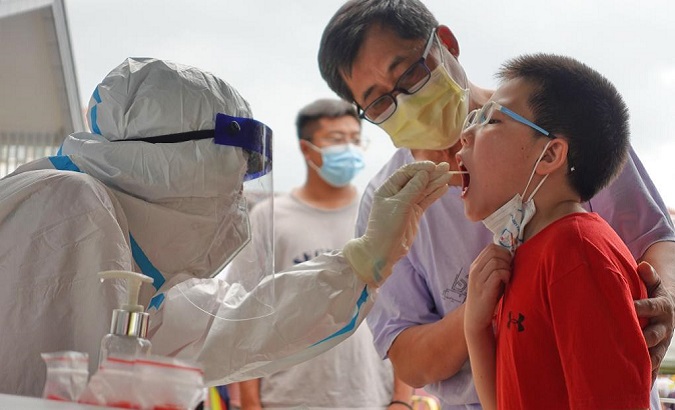 A medical worker takes a swab sample for a COVID-19 test, Laishan District, China, Aug. 5, 2021.