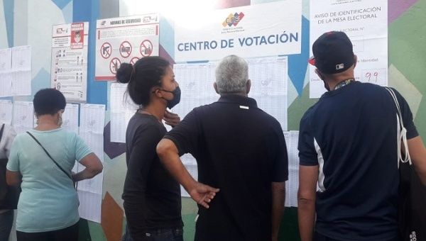 People look at a voting list, Venezuela, Aug. 8, 2021.