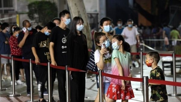 People queue up to receive testing at a nucleic acid testing spot in Zhengzhou, capital of central China's Henan Province, Aug. 8, 2021. 