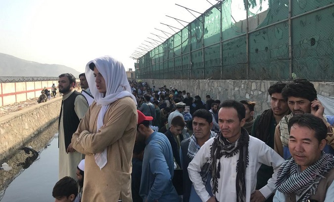 Afghans gather near a gate of the Kabul airport, Afghanistan, Aug. 22, 2021.