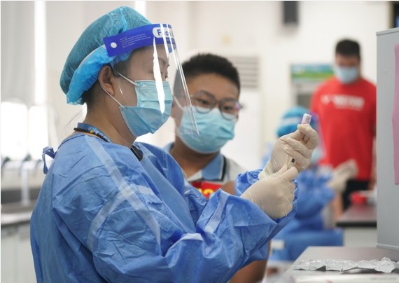 A student waits to receive a dose of COVID-19 vaccine at a vaccination point of Wenshu middle school in Nanjing, east China's Jiangsu Province, Aug. 23, 2021.